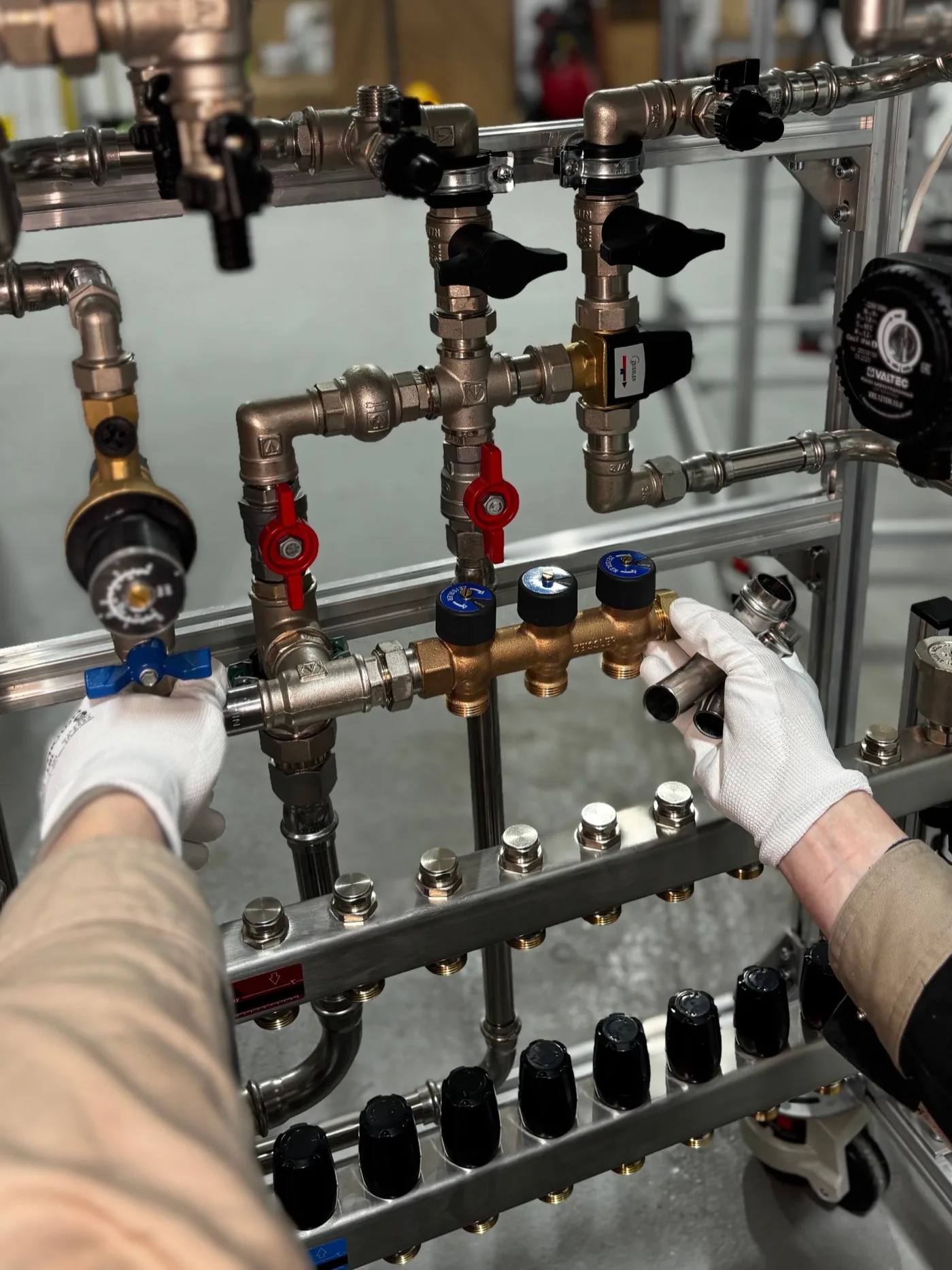 Gloved hands fitting valves on a water manifold