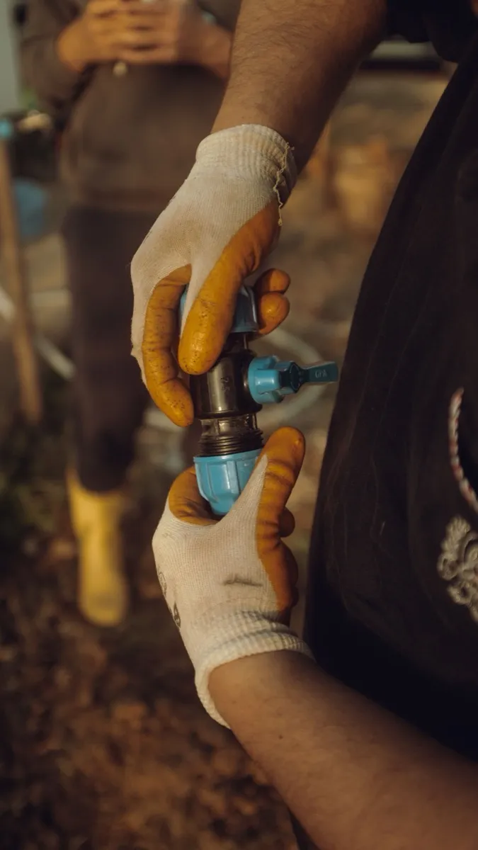 Gloved hands fitting a pipe connection