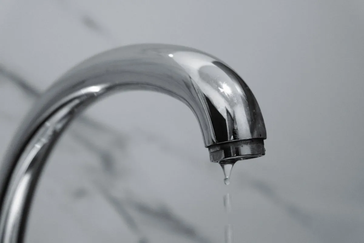 Chrome bathroom tap with a drip falling